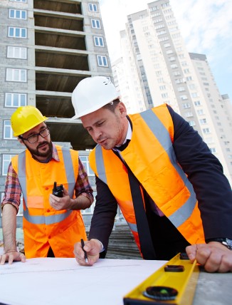 Ingenieros de Constructora Inteligente revisando planos de construcción en obra